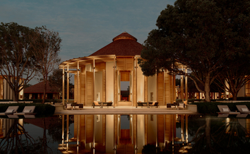 Bar exterior at Amanyara resort, Turks and Caicos, reflected in still water at dusk.