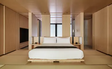 Principal bedroom with tatami flooring and floor-to-ceiling windows at Aman Kyoto resort.