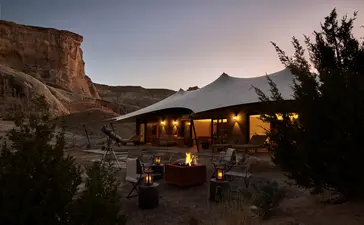 Two-bedroom Grand View Pavilion at Amangiri resort, illuminated at dusk with desert landscape.