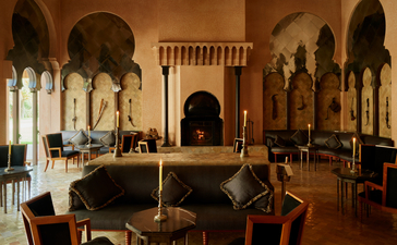 Bar at Amanjena resort with Moroccan arches, columns and warm earth tones.