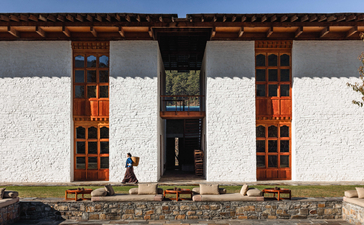 Aman Bhutan Bumthang Lodge exterior with whitewashed walls and traditional wooden window frames.