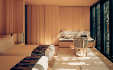 Serene bedroom at Aman Kyoto with twin beds, warm lighting, and traditional Japanese architectural details.