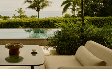 Salle de séjour ouverte sur étang et jardins tropicaux à Amanera, resort en République Dominicaine.