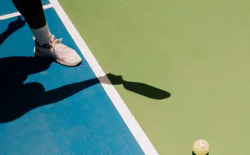 Tennis racquet and balls on blue court at Amanera resort, Dominican Republic.
