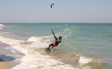 Kitesurfer in turquoise waves at Amanera resort, Dominican Republic.
