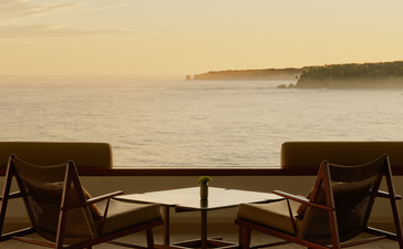 Two wooden chairs facing the sea at dawn, Amanera resort, Dominican Republic.