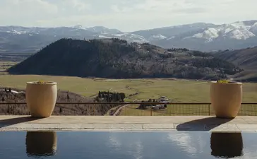 Infinity pool at Amangani overlooking the Wyoming landscape, with snow-capped mountains in the distance.
