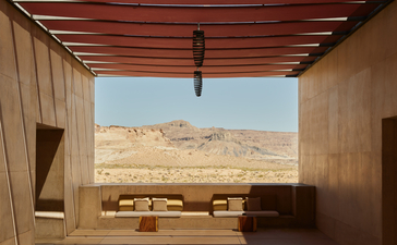 Wooden deck at Amangiri with view towards desert landscape and seating area beyond.