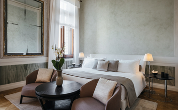 安缦威尼斯酒店的宽敞卧室，配有大床、坐卧区和落地窗。