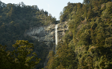 Waterfall cascading down forested cliffs at Amanemu resort, Kumano Kodo.