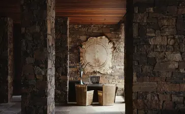 Amangani lobby entrance with stone archway and wooden ceiling details.