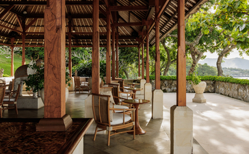Wooden bar pavilion at Amankila with open sides, comfortable seating, and views towards Bali's landscape.