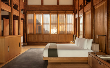 Principal bedroom with wooden panelling and platform bed at Amanyangyun villa, China.