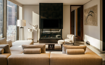 Lounge dell'Aman New York con camini, sedute in tonalità neutre e ampi spazi luminosi.