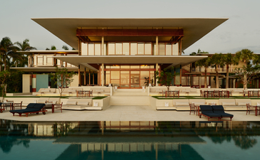 Exterior of Casa Grande at Amanera resort in Dominican Republic, with modern architecture reflected in the pool at dusk.