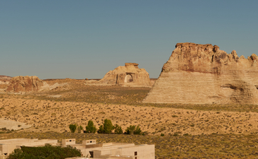 Amangiri's expansive desert landscape with terracotta rock formations and poolside loungers in the foreground.