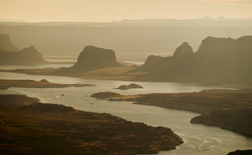 Aerial view of Amangiri's surrounding desert landscape with distinctive rock formations and winding waterway at dusk.