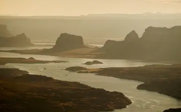 Aerial view of Amangiri's surrounding desert landscape with distinctive rock formations and winding waterway at dusk.