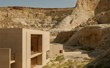 Amangiri nestled into a desert cliff face, with minimalist architecture and natural stone surroundings.