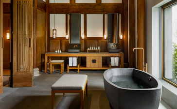 Spacious bathroom at Amanyangyun with wooden panelling, dual vanity, soaking tub and natural light from large windows.