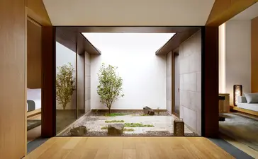 Suite courtyard at Amanyangyun with wooden screens framing a serene summer garden view.