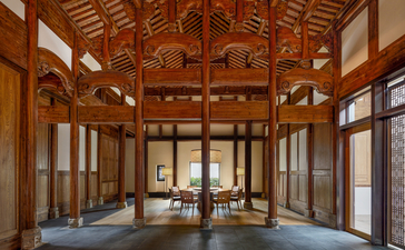 Villa dining and lounge area at Amanyangyun, China, with timber lattice ceiling and traditional architectural details.