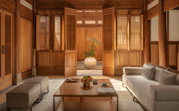 Lounge area at Amanyangyun Shanghai with wooden panelling, two grey sofas, and a central wooden table with decorative objects.