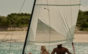 Voilier Hobie Cat avec passagers naviguant dans les eaux turquoise à Amanyara.