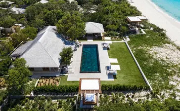 Aerial view of a five-bedroom beach sala villa at Amanyara resort, Turks and Caicos, featuring a pool and manicured gardens.