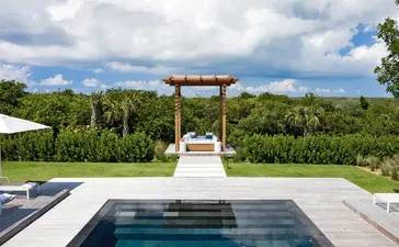 Sala de playa con piscina infinita y vistas a la vegetación tropical en Amanyara, resort en Turks y Caicos.