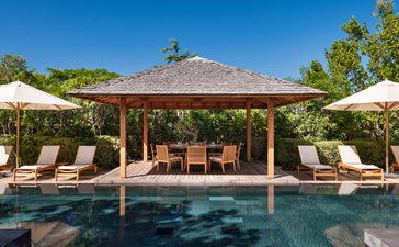 Five-bedroom beach sala villa at Amanyara with thatched roof, lounge seating, and infinity pool.