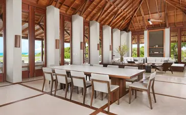 Sála de playa con techos de madera, mesas de comedor y vistas al mar en Amanyara resort.