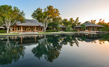 Vila Serenidade com cinco quartos refletida em lagoa tranquila ao amanhecer em Amanyara.