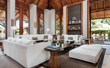 Serenity Villa sitting area at Amanyara resort, with white sofas, wooden beams, and open views to the garden.