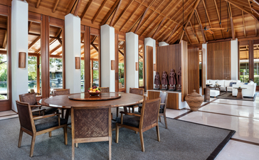 Sala de estar espaçosa da villa Serenity em Amanyara, com vigas de madeira e janelas amplas.