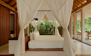 安缦涯澜度假村的海洋亭pavilion内，白色帐篷床幔围绕着靠窗的床铺，室内融合木质元素与自然采光。