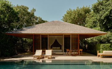 アマンヤラ リゾートのプール パビリオン。大きな屋根が張り出し、木製の柱で支えられ、プールサイドに佇む建築物。
