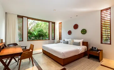 Chambre principale spacieuse de la villa six chambres d'Amanyara, avec lit king-size et bureau en bois.