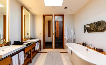 Salle de bains spacieuse de la villa six chambres à Amanyara, avec baignoire et vasques doubles.