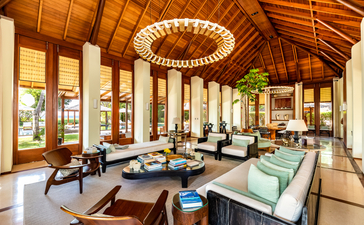 Six-bedroom Amanyara villa with open-plan living area, wooden ceiling beams, and floor-to-ceiling windows overlooking Turks and Caicos.