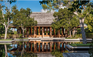 アマンヤラのビーチサラヴィラ、6ベッドルーム。池に映る木造建築とトロピカルガーデン。