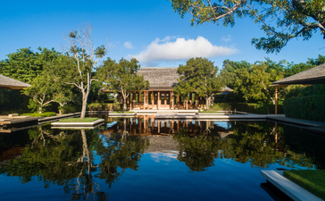アマンヤラのビーチ・サラ・ヴィラから見た、池に映る6ベッドルームの建物と緑豊かな庭園。