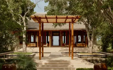 安缦涯澜度假村的艺术家别墅外观，砖红色建筑与木质结构相融合。