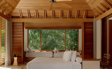 Principal bedroom in a three-bedroom villa at Amanyara resort, Turks and Caicos, with wooden vaulted ceiling and garden views.