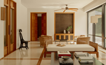 Two-bedroom pool villa interior at Amanyara resort with wooden dining table and warm earth tones.