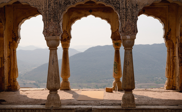 Stone arches frame mountain views from Amanbagh's terrace.