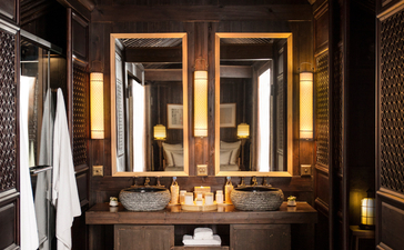 Bathroom at Amanfayun with illuminated mirror, dark cabinetry, and warm lighting.