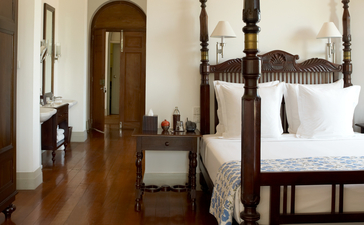 Principal bedroom at Amangalla with four-poster bed and wooden furnishings.