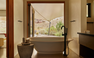 Salle de bains du pavillon d'hébergement à Amangiri, avec baignoire autonome face à une fenêtre panoramique.