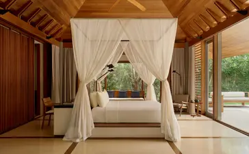 Deluxe pool pavilion with draped four-poster bed at Amanyara resort, Turks and Caicos.